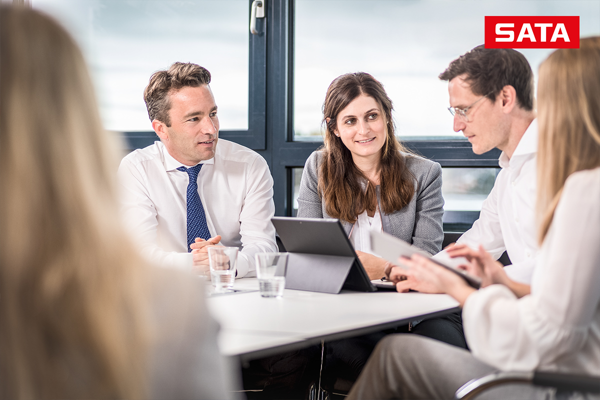 F&uuml;nf Personen im Teammeeting an einem Konferenztisch.