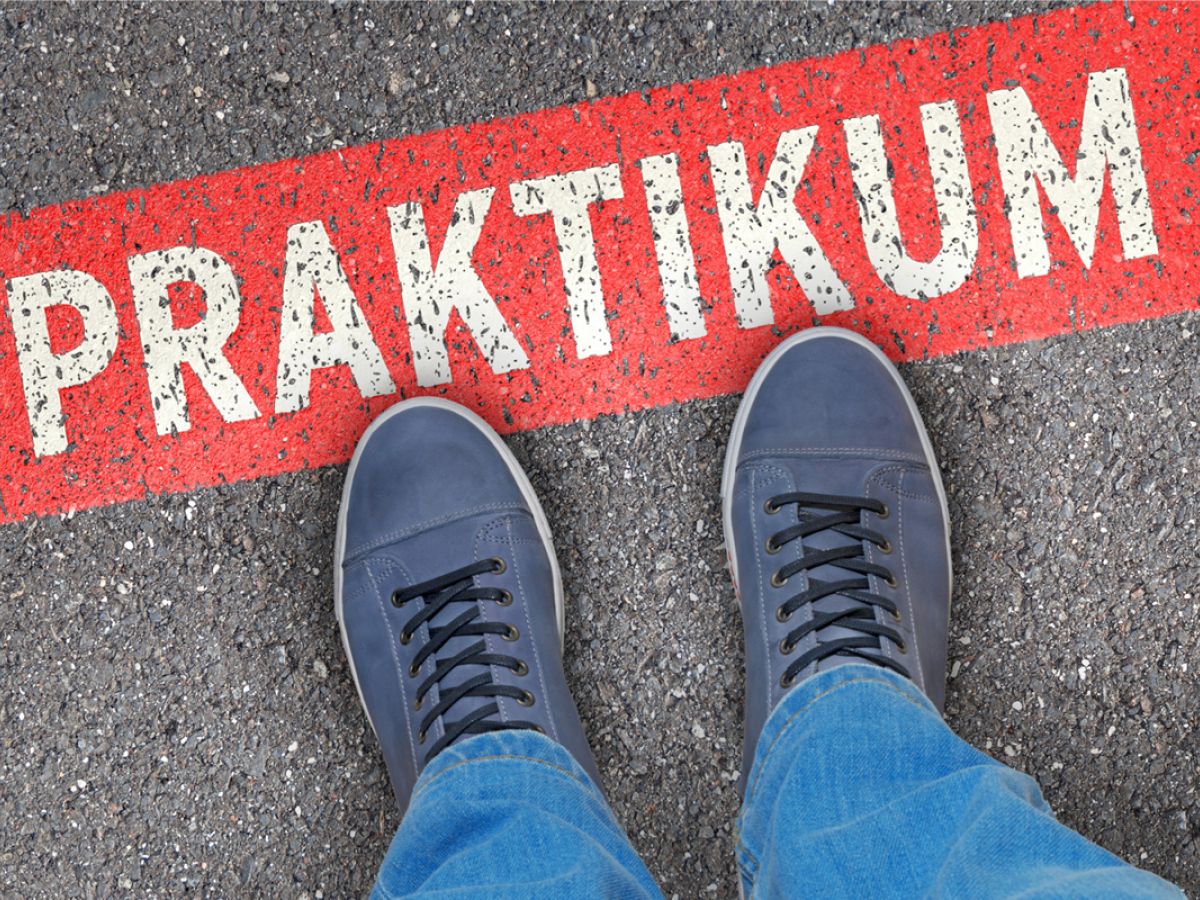 Person steht vor einem roten Streifen mit dem Wort ‚Praktikum‘.